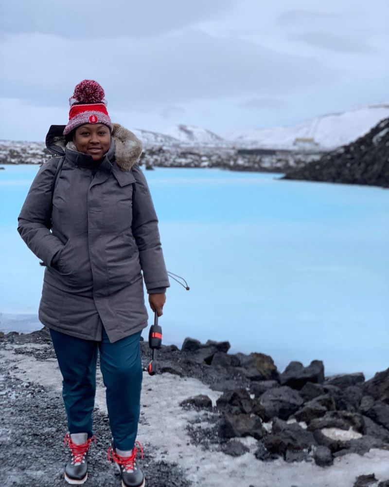 Valicia in winter gear beside the milky blue waters of the Blue Lagoon